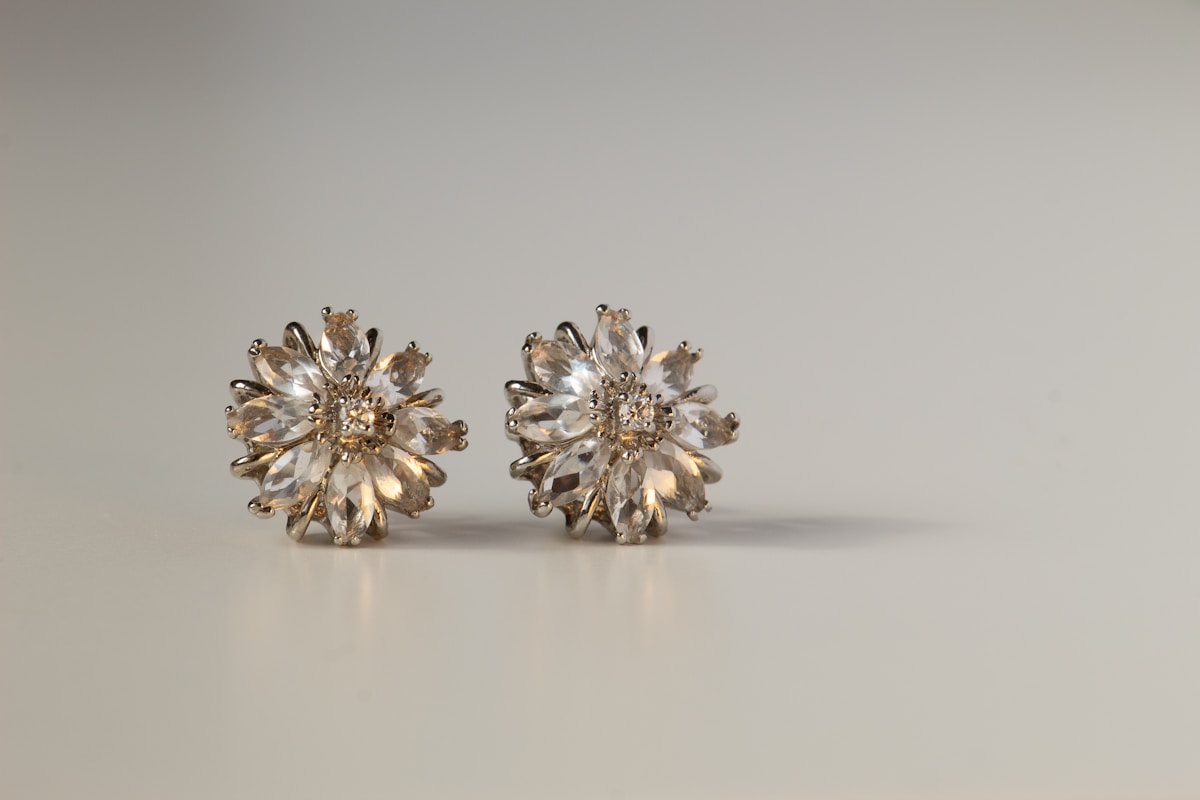 A pair of diamond drop earrings on a white background