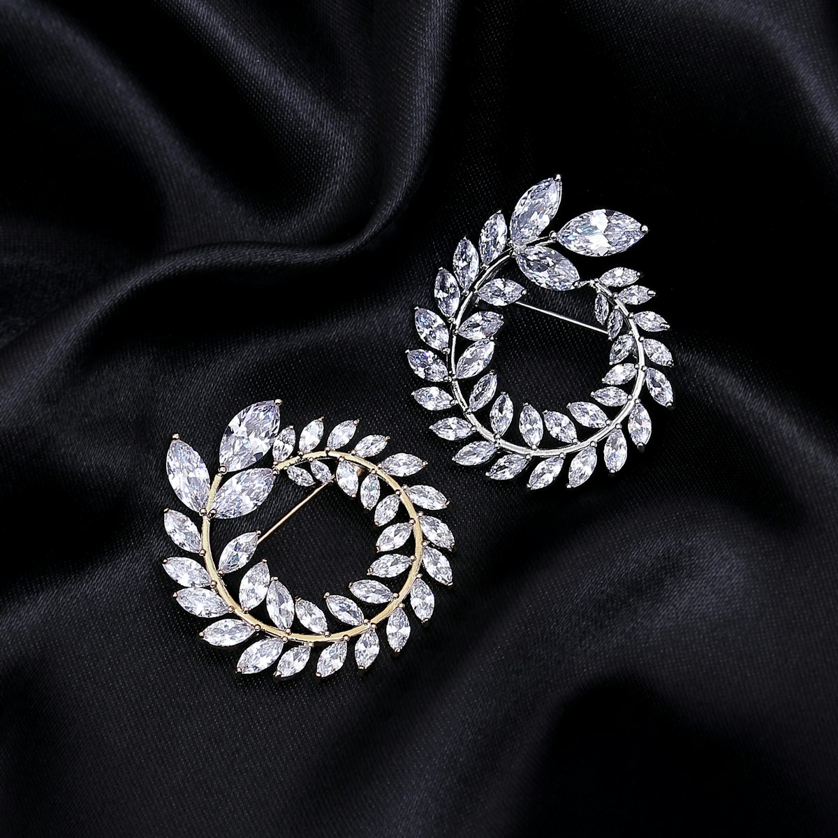 A pair of diamond stud earrings on black cloth