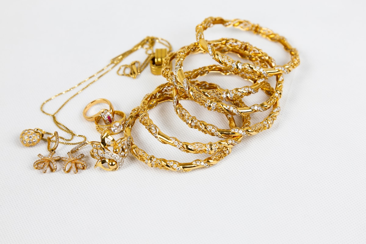 A gold chain necklace on a white surface